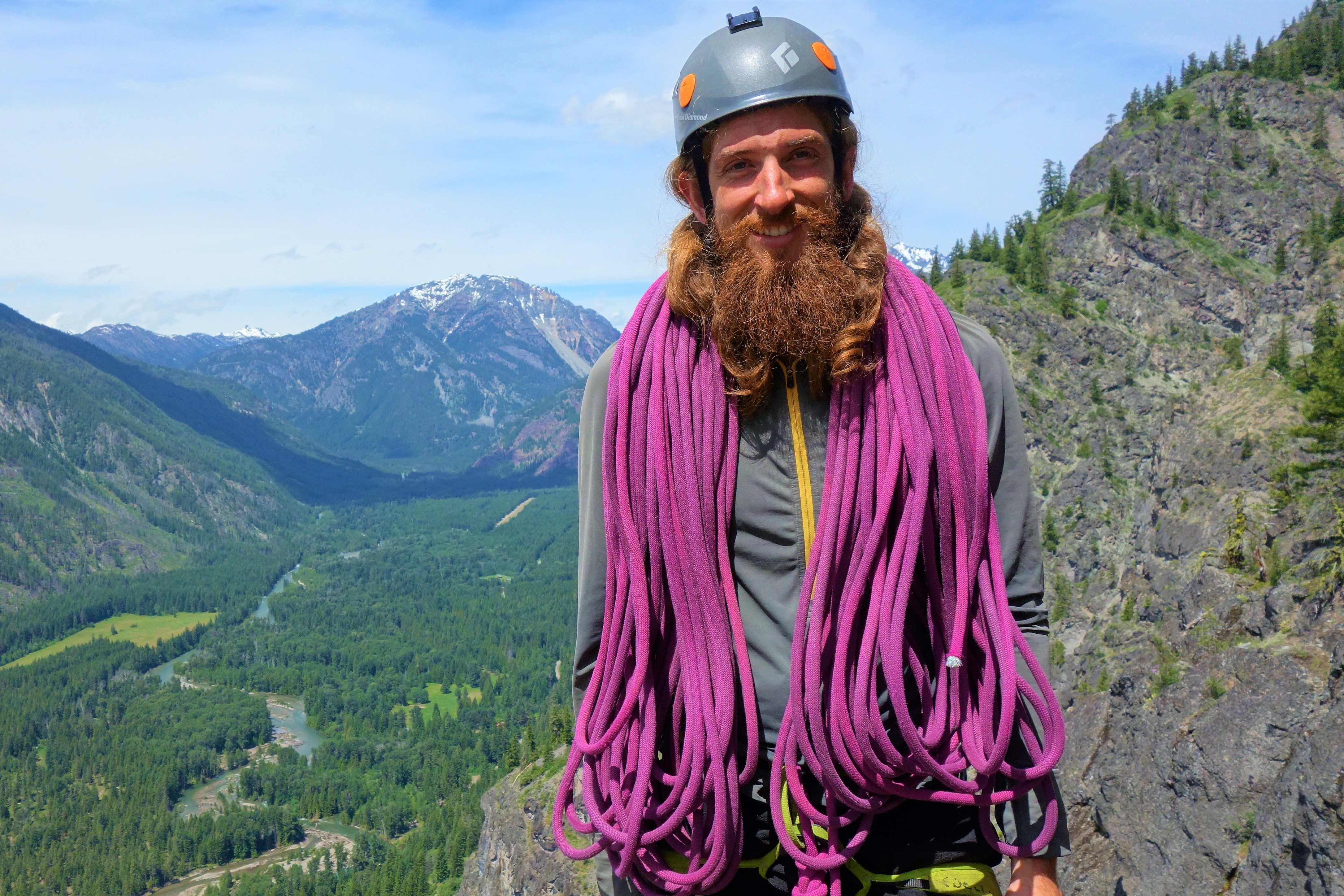 Gabriel Wechter in the mountains, wearing a helmet with climbing rope around his shoulders