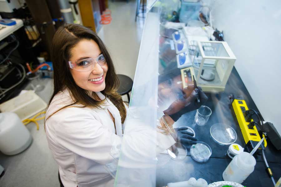 A graduate student working in a lab in full protective gear
