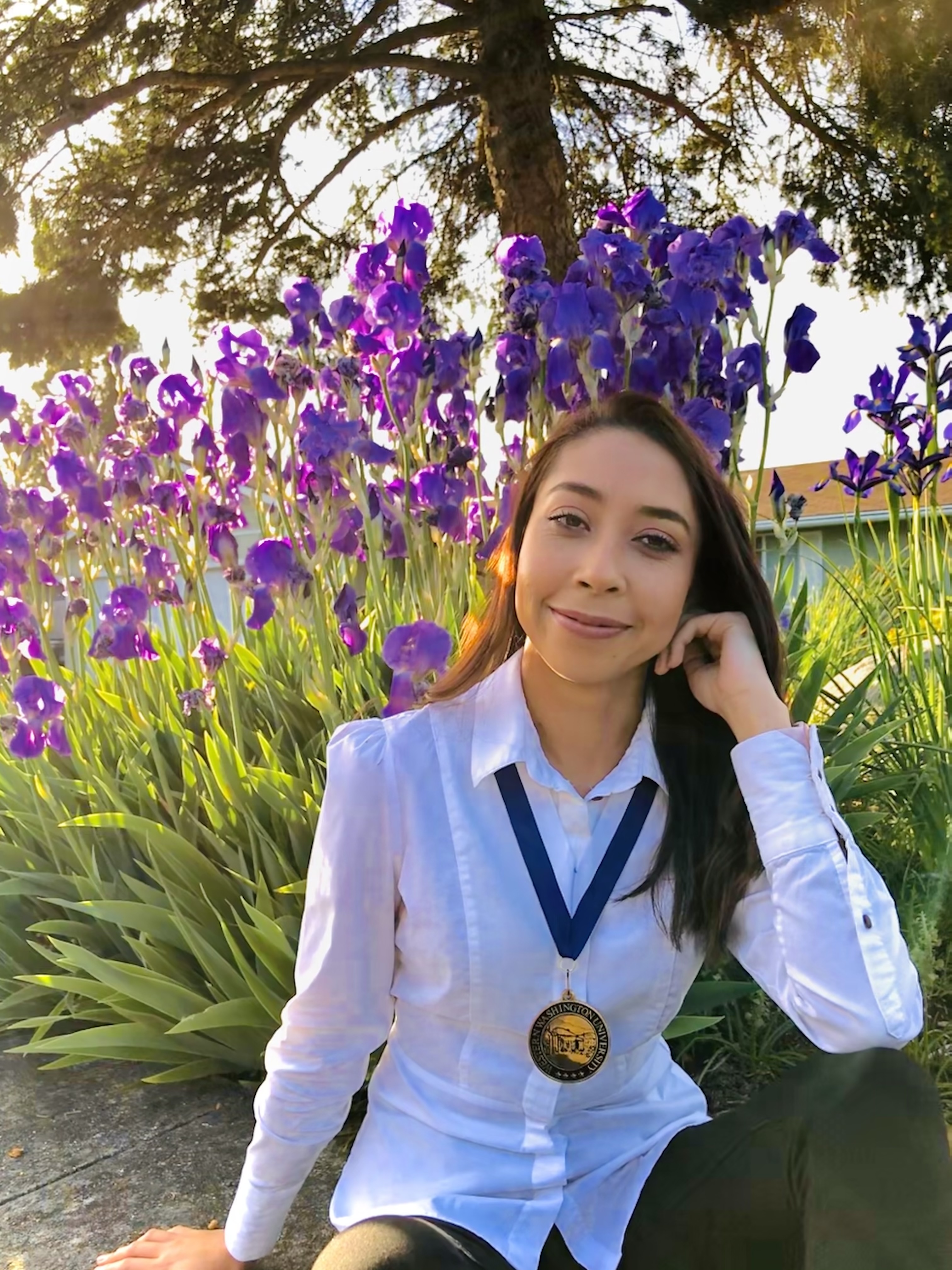Azucena Zavala Montalvo wears her Presidential Scholar medal outside in front of a patch of purple iris.College of Science and Engineering Presidential Scholar Melody Gao wears her medal outdoors on Western's campus.Kathryn Anderson wears her capgown and stole as she holds her diploma on the lawn in front of Old Main as the cherry tree blooms overhead.Brahm VanWoerden poses with his medal for being a Presidential ScholarSummer Pascual poses in her graduation capCFPA Presidential Scholar Luke