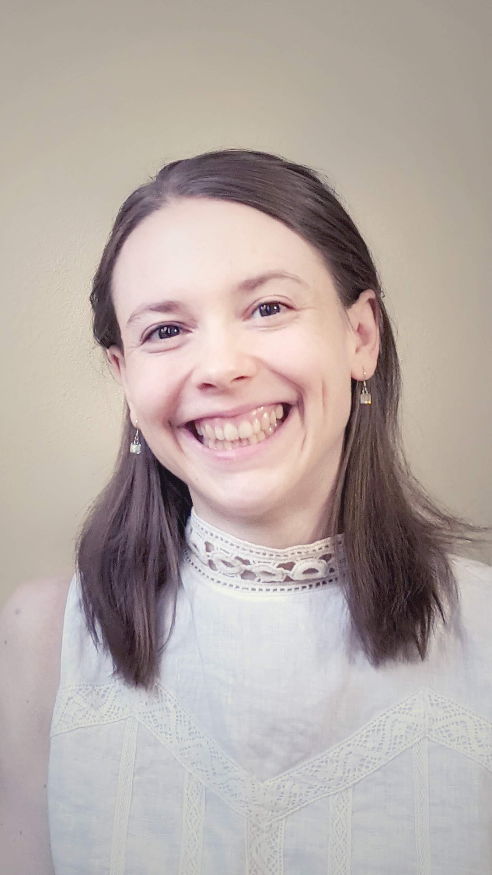 WWU outstanding graduate Student Pippa Hemsley, smiling with a gray background