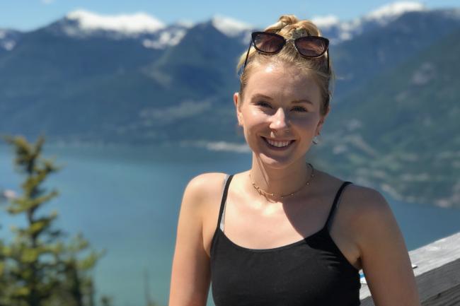 WWU grad Hannah Hennig Smiling with body of water and mountain in the background