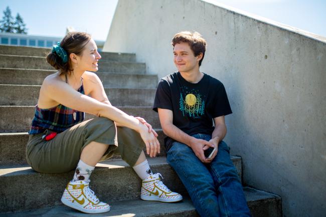 Two Western Washington University students sitting on concrete stairs