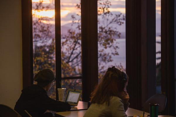 people studying near windows at sunset
