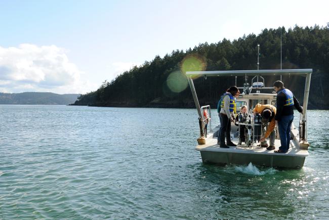 students working on a research vessel in the Salish Sea