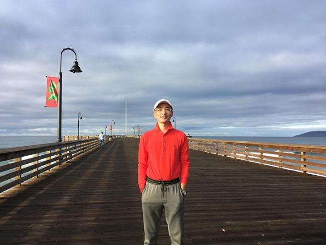WWU graduate student Kang Wu standing on boardwalk that stretches behind him